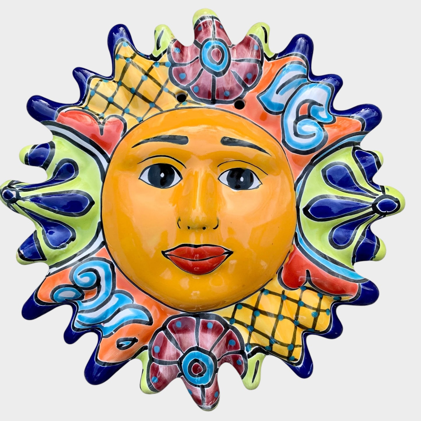 Decorative Talavera sun-shaped wall art with colorful face design on a white background