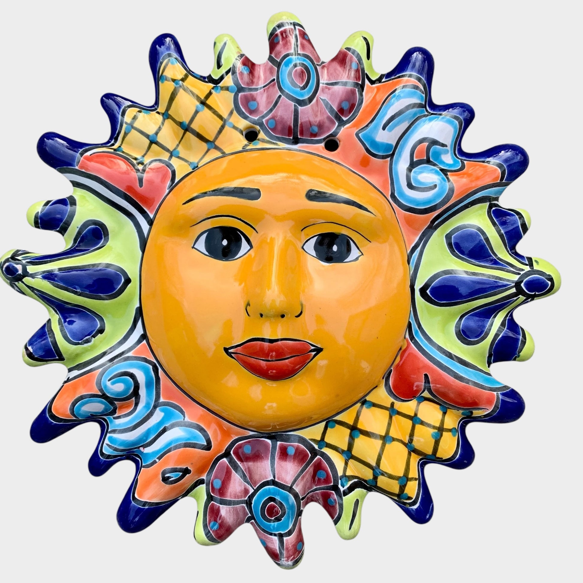 Decorative Talavera sun-shaped wall art with colorful face design on a white background