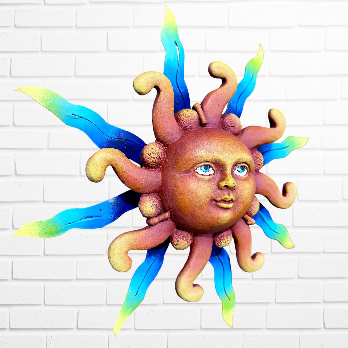 A whimsical sun wall sculpture with big blue eyes, a smiling face, and vibrant, left angle.