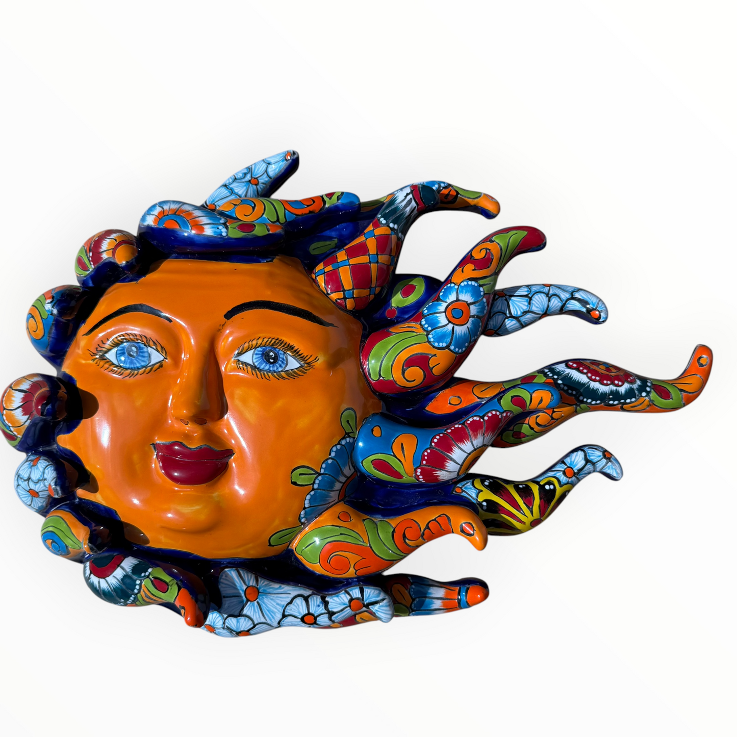 A colorful hand-painted Talavera ceramic sun wall sculpture with big wavy rays on a plain white background.