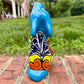 Coyote figurine on a brick surface with a garden background Back view
