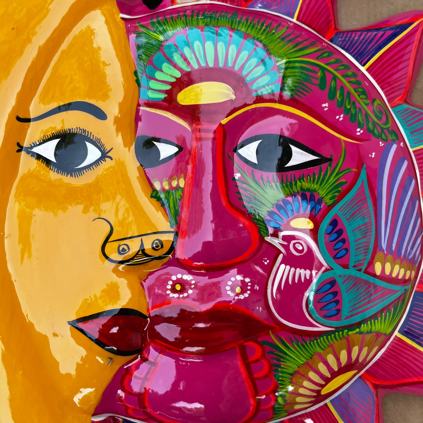 Folk art sun and moon eclipse close up faces 