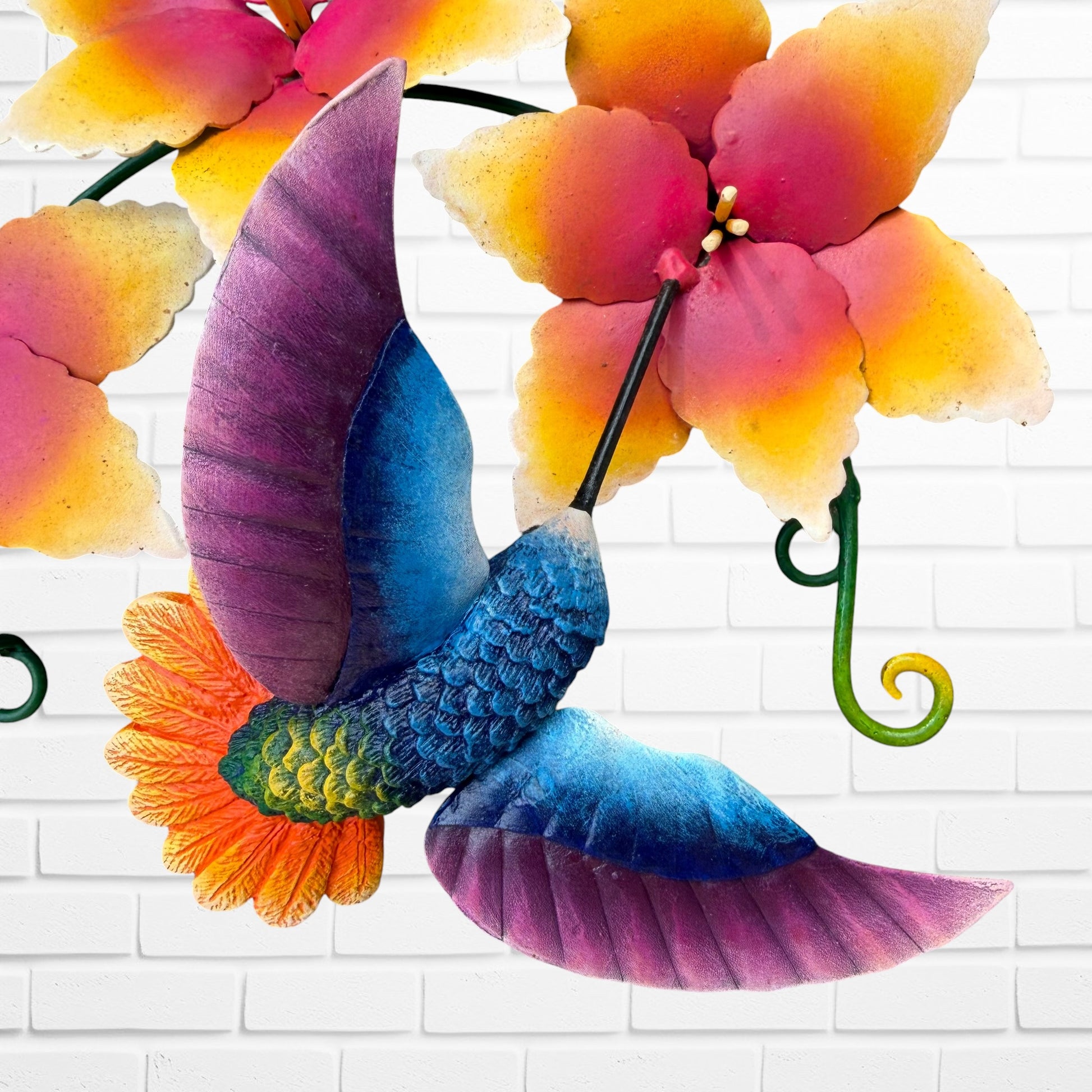 Metal hummingbird sculpture with Vibrant yellow flowers bird close up