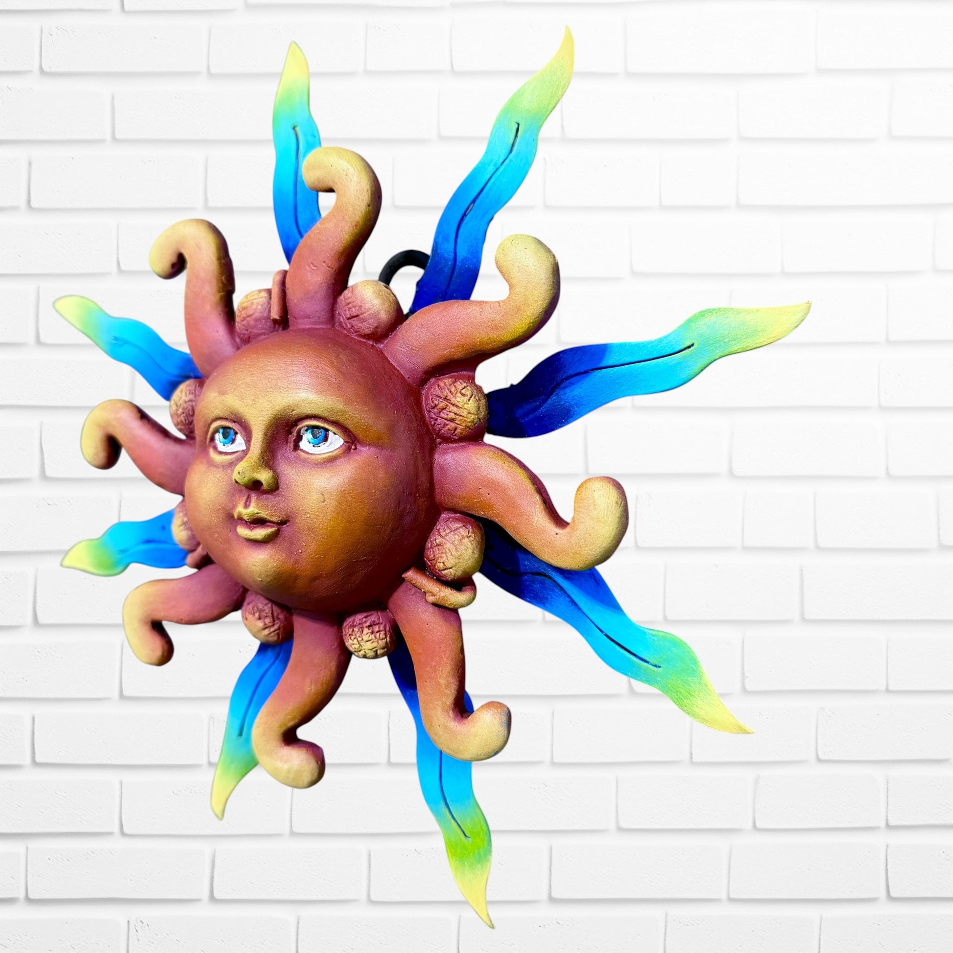 A whimsical sun wall sculpture with big blue eyes, a smiling face, and vibrant, right angle,