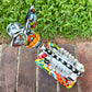 A colorful hand-painted Talavera Catrina donkey figurine, standing on a colorful floral base in an outdoor backyard setting, top view showing backbone.
