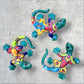 Three colorful Talavera ceramic lizards on a textured surface