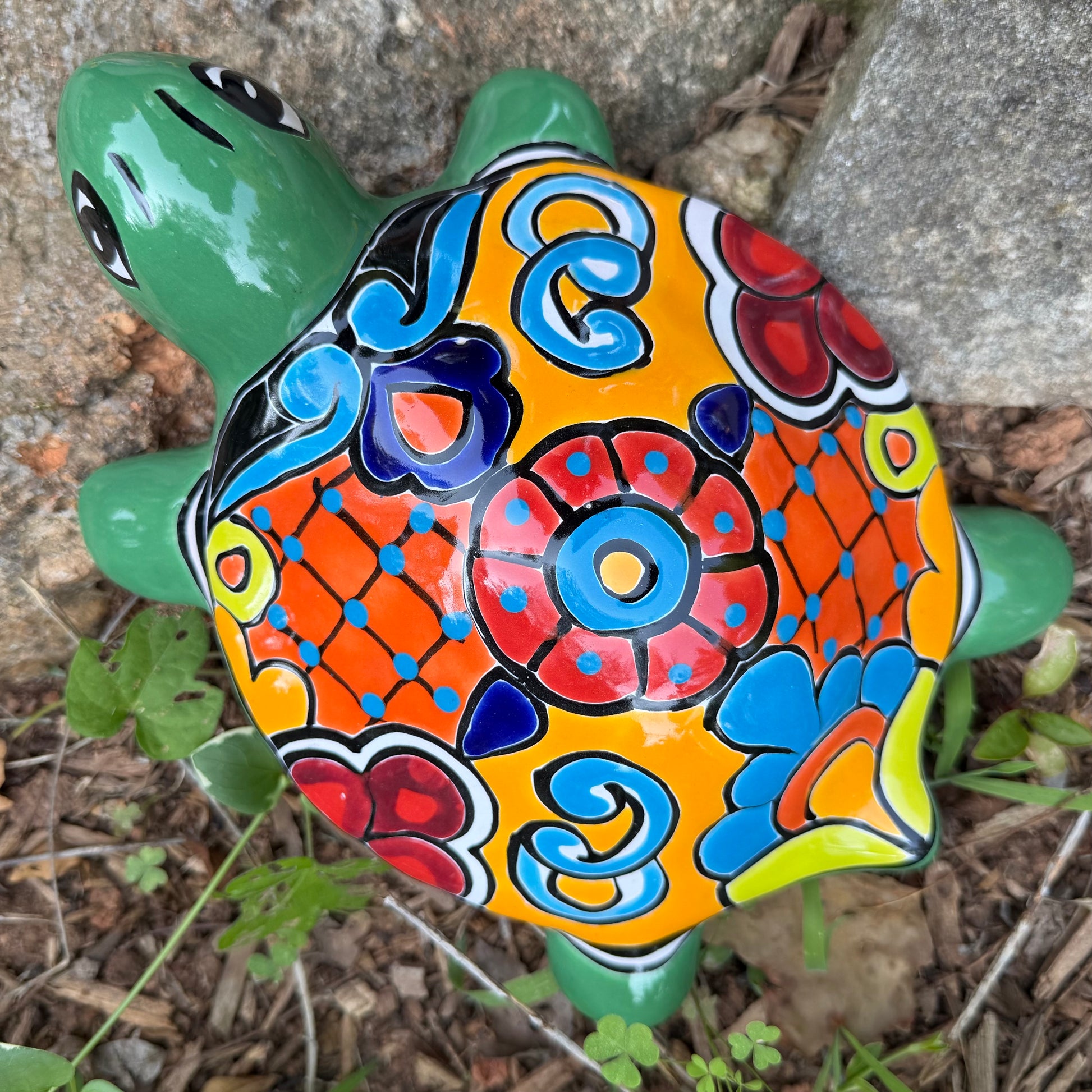 Colorful ceramic turtle with decorative shell on a natural background top view