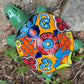 Colorful ceramic turtle with decorative shell on a natural background top view
