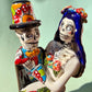 A colorful Day of the Dead figurine of a skeleton bride and groom embracing, with the groom holding the bride. The figurine features vibrant painted details including a orange and white patterned dress, a multicolored hat, and dark hair, set against a plain light background. Close up of faces.