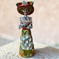 Mexican catrina talavera doll with calla lilies on the front of her dress. wearing a colorful dress with a big feathered hat.  