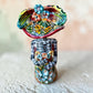 Mexican catrina talavera doll with calla lilies on the front of her dress. wearing a colorful dress with a big feathered hat.   Top view of doll.